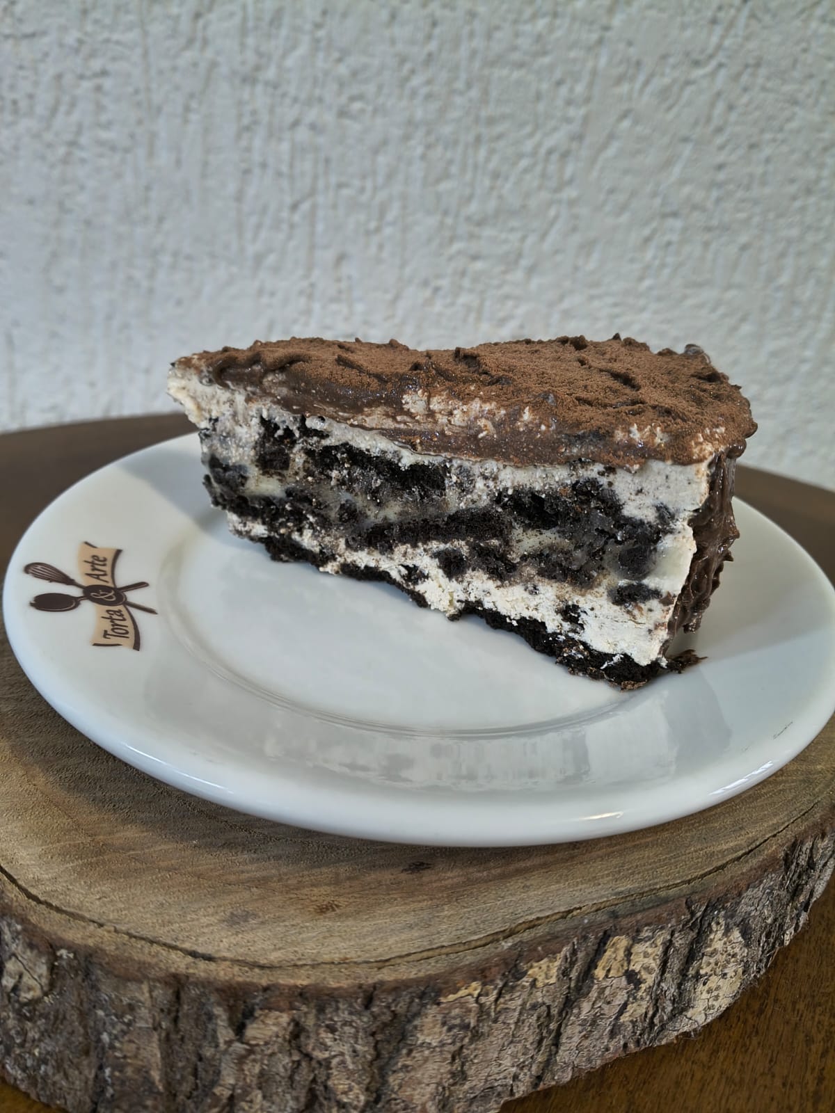 Fatia de torta de Oreo com camadas de biscoito de chocolate e creme, coberta com ganache