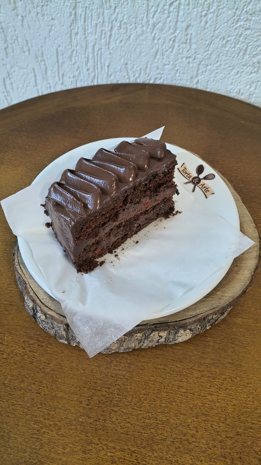 Fatia de bolo de chocolate trufado, com massa fofinha e cobertura de ganache