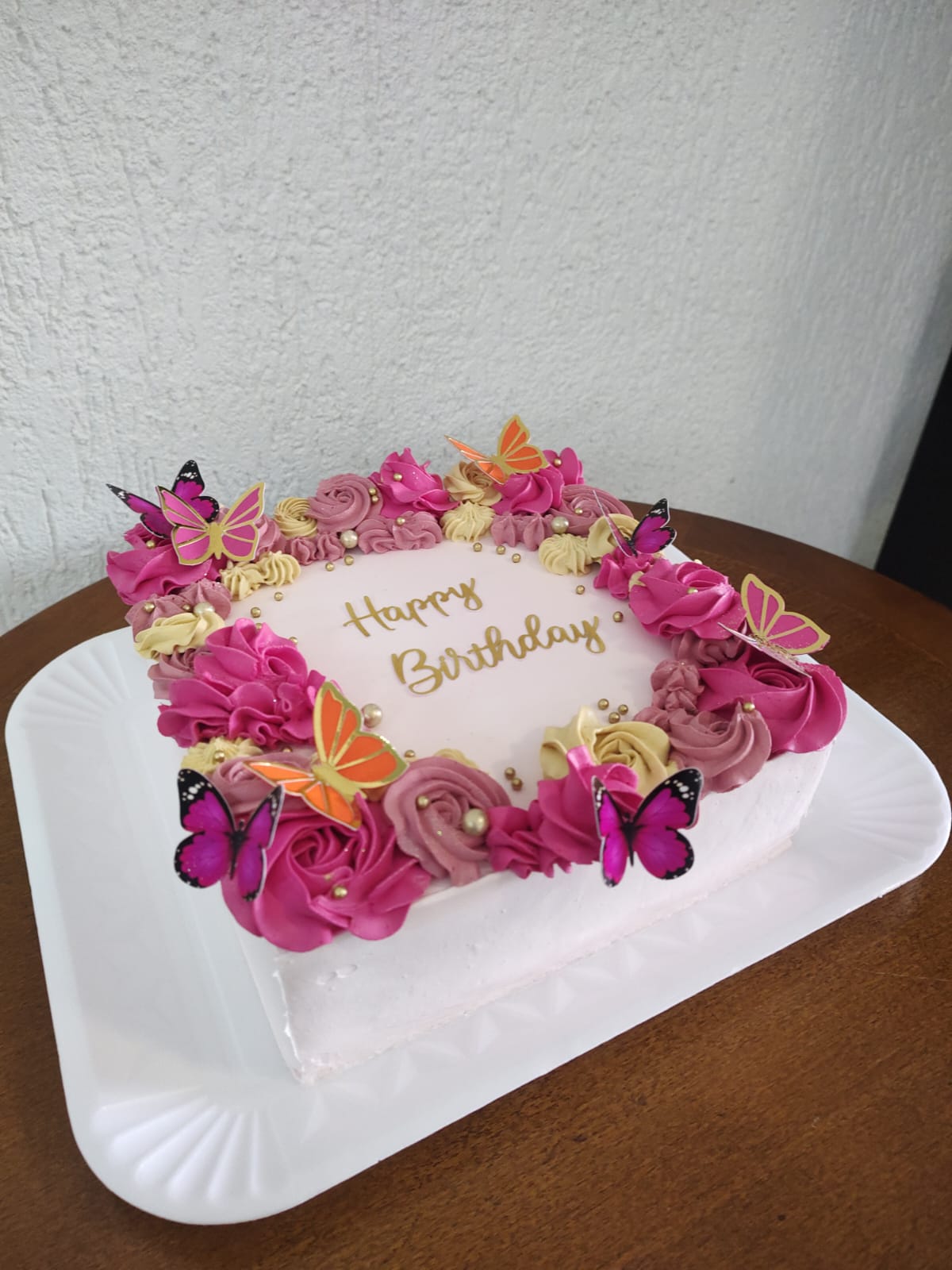 Bolo rosa com cerejas no topo